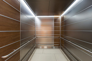 FSRT729 Внутренняя часть лифта Levele-103 с панелями из нержавеющей стали с отделкой из морского камня и индивидуальным ламинатом; потолок из нержавеющей стали с отделкой из морской керамики в центре матери и ребенка в Abbott Northwestern and Children's H Forms-surfaces 