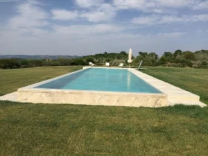 INDALO PISCINE Пейзажный бассейн из травертина с водопадом